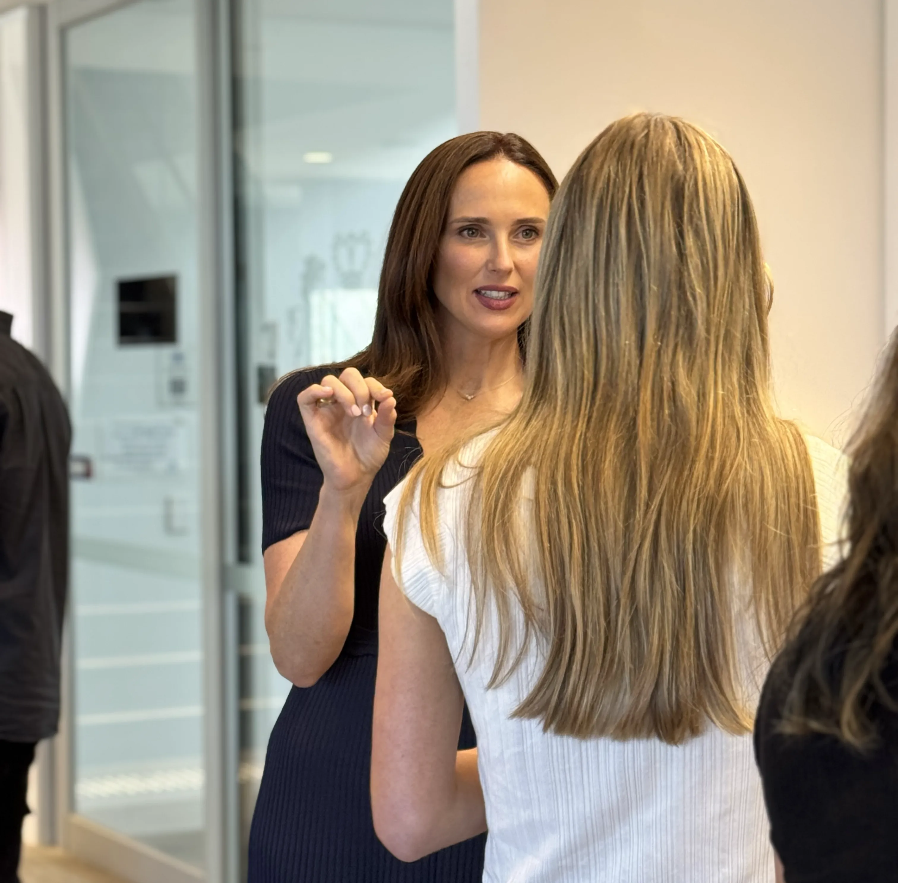 Lucy Quick, founder of the Balanced Elite, having a conversation at a workplace wellbeing event with a woman with blonde hair.