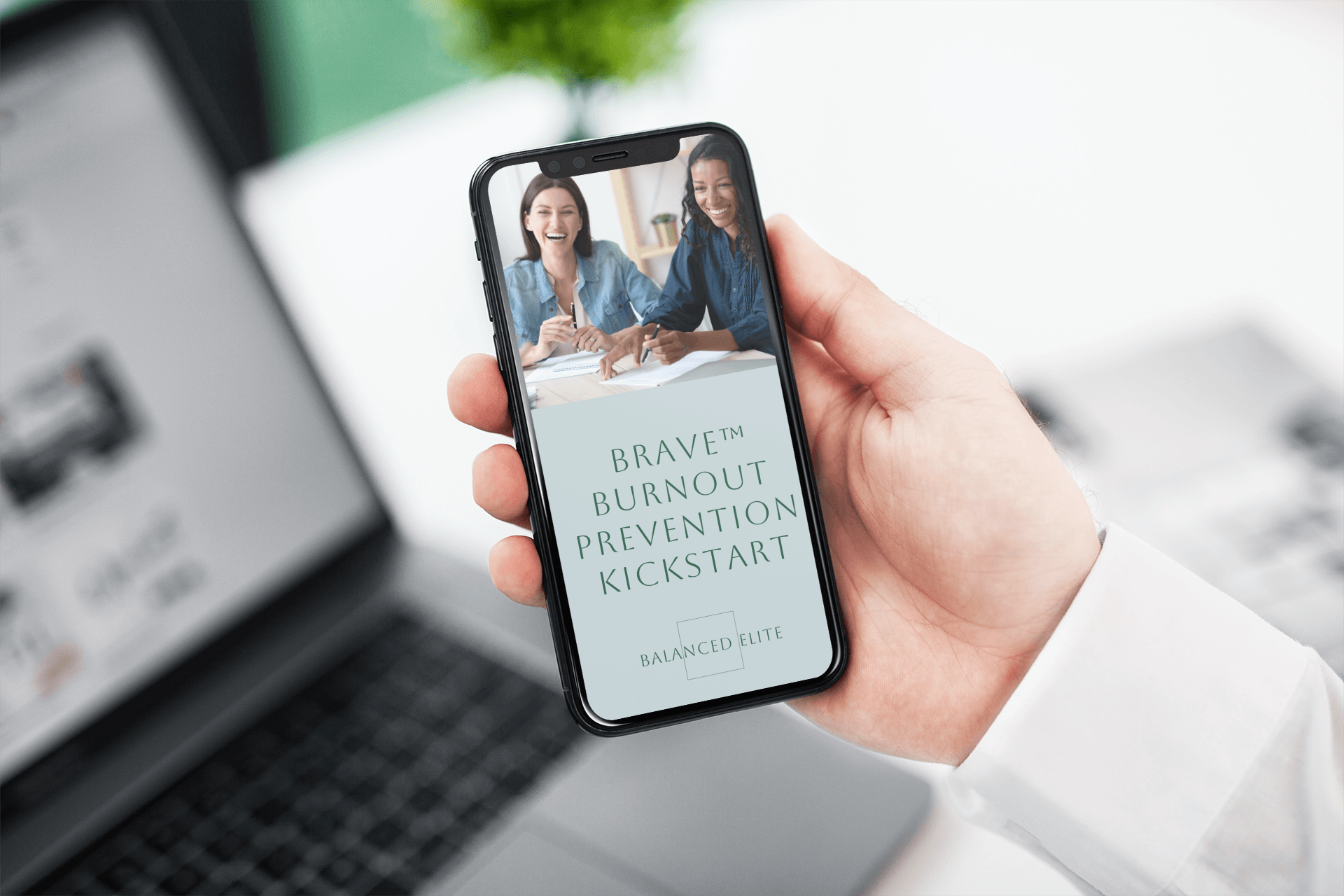 A woman holding her phone with the eBookd download of the BRAVE Burnout Prevention KIckstart.