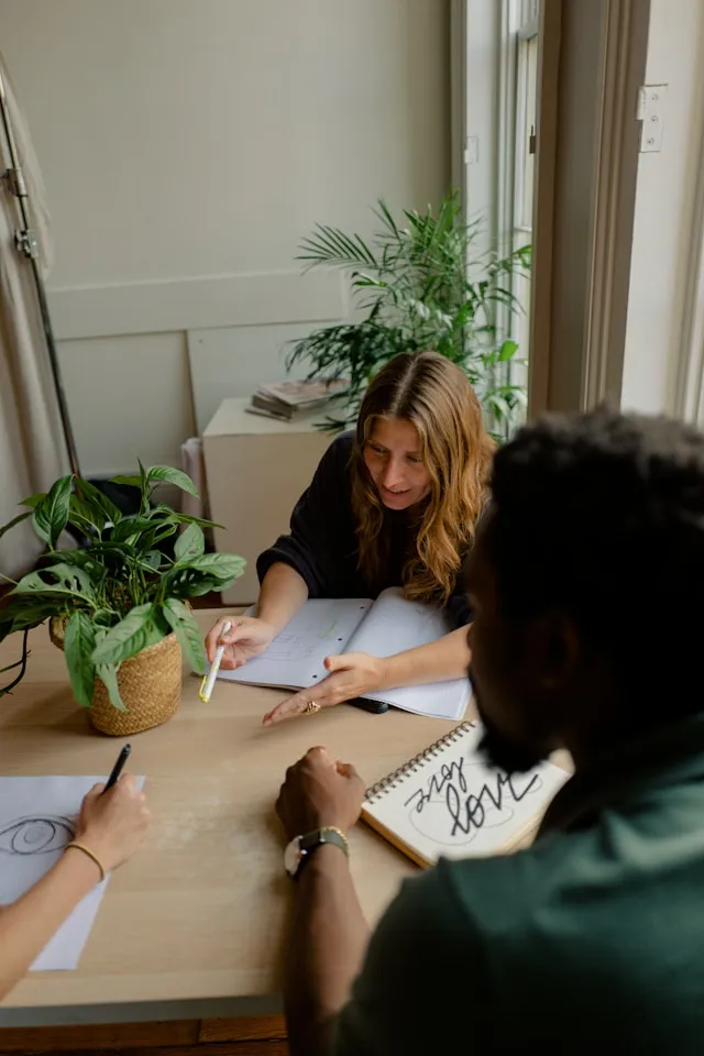 Two colleagues brainstorming over a board table about Leading Through Change & Uncertainty