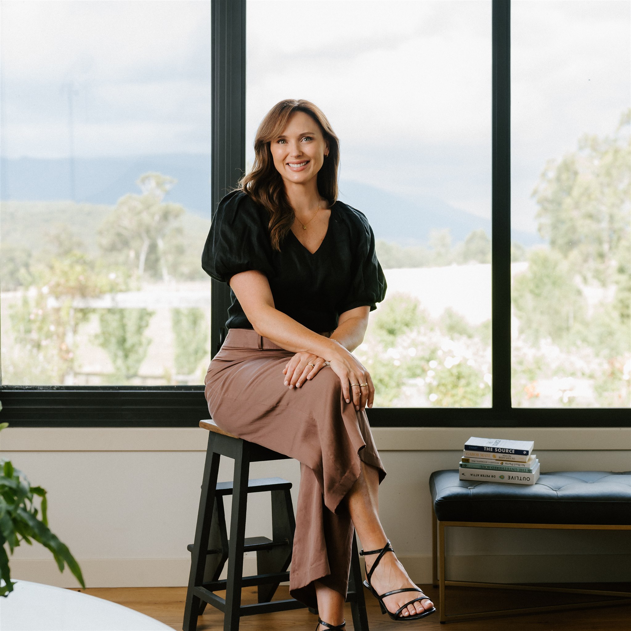 Lucy Quick, founder of the Balanced Elite, sitting on a stall smiling happily at the camera.