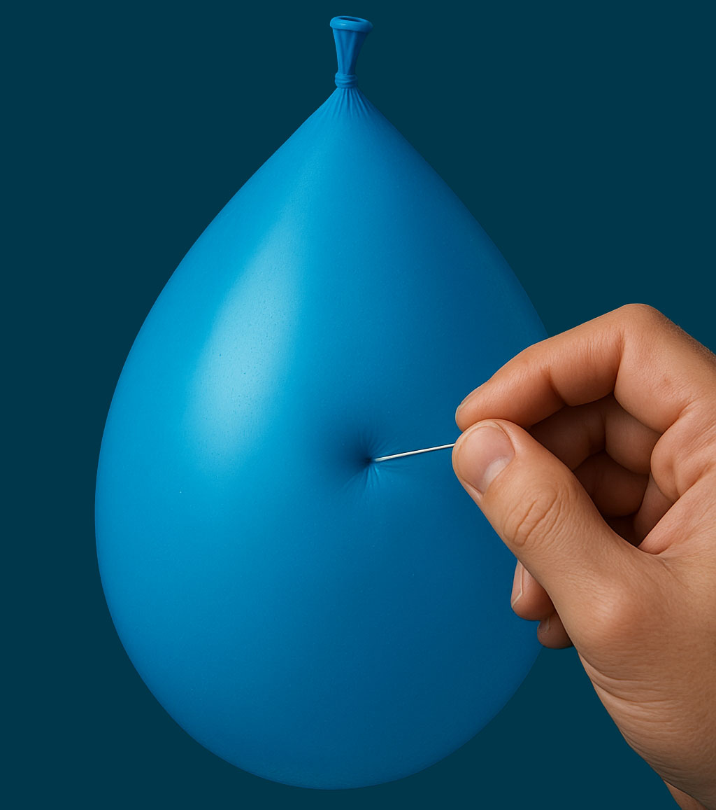 Blauer Balloon an den eine Hand eine Nadel drücke