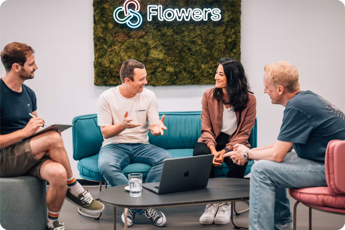 Arbeitendes Team diskutiert mit Laptop in der Mitte