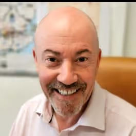 Smiling bald middle-aged man in white shirt, warm expression