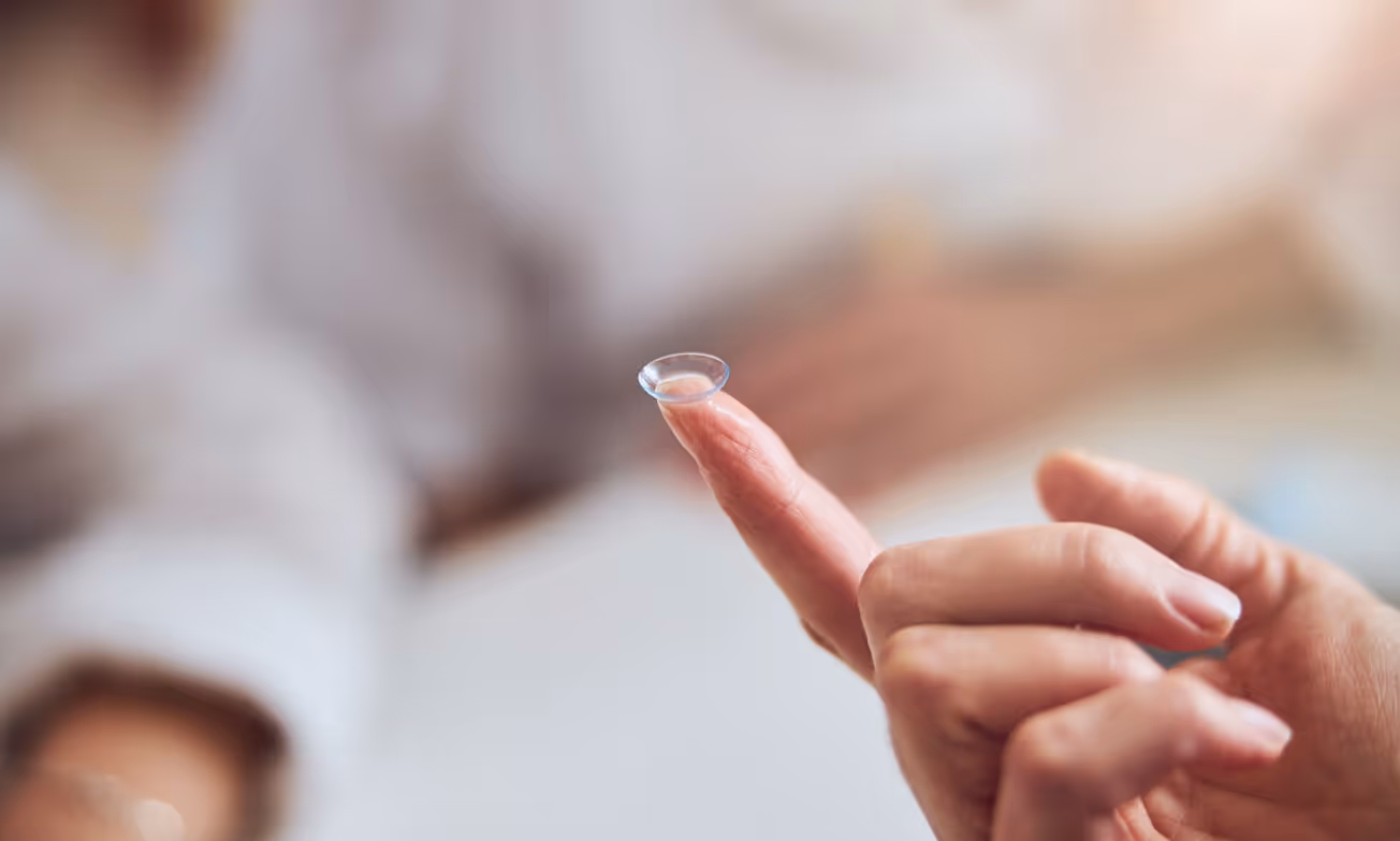 Close-up of a contact lens balanced on a fingertip