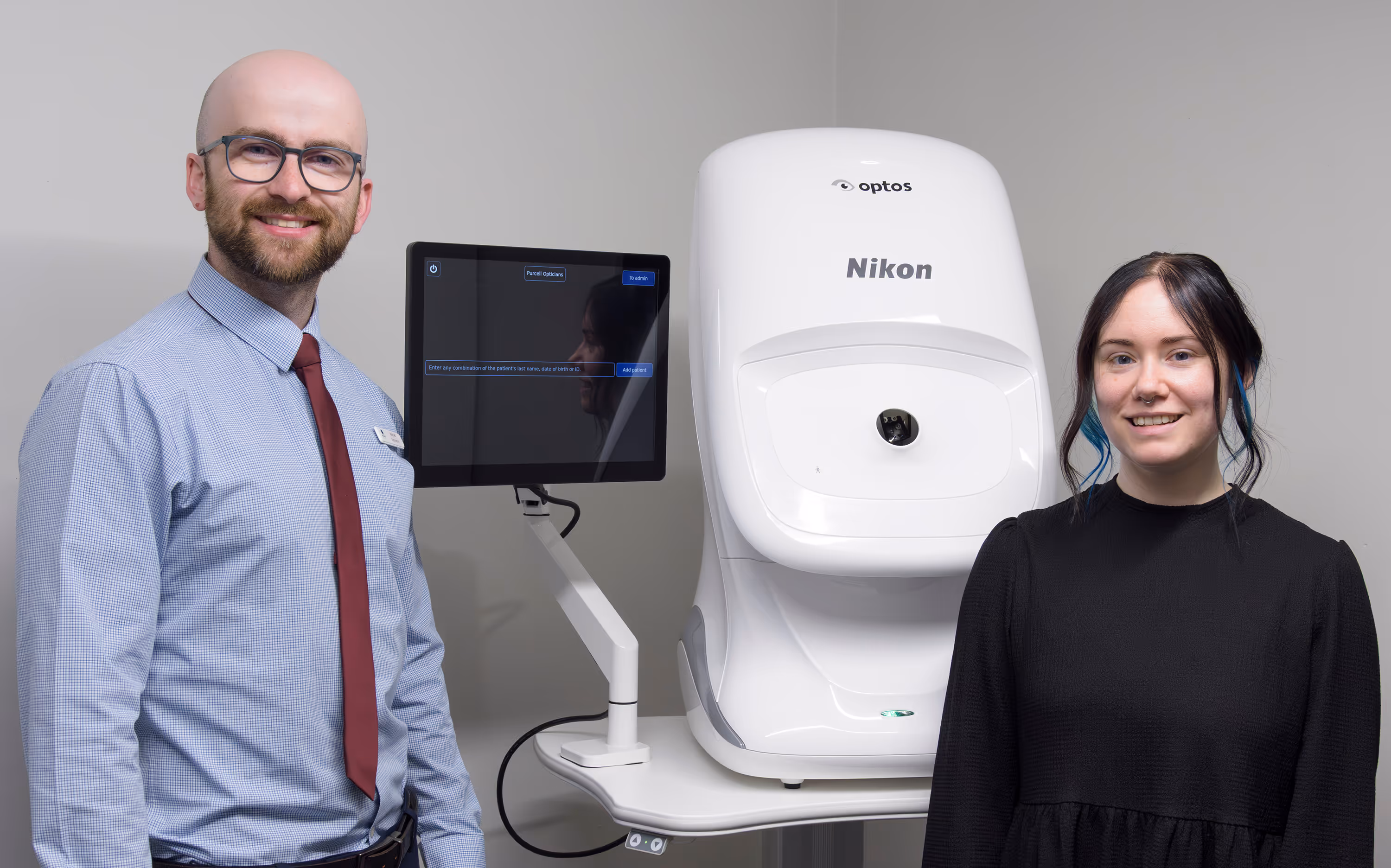 Two people posing with Nikon optos medical imaging equipment