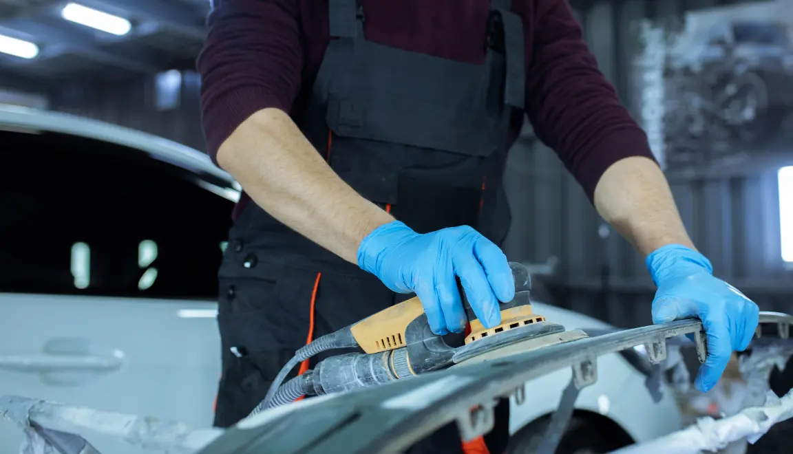 Un carrossier à l'ouvrage dans un atelier de réparation automobile.