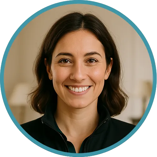 Smiling woman with shoulder-length dark hair wearing a black zip-up jacket inside a softly lit room.