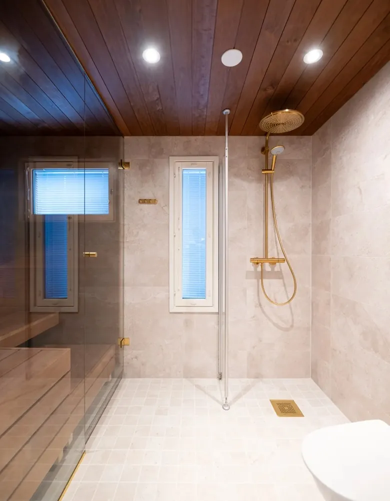 Valmis moderni kylpyhuoneremontti, vaaleat laatat ja lasiseinä, toteutus Ykkös-Kylppäri Turku.