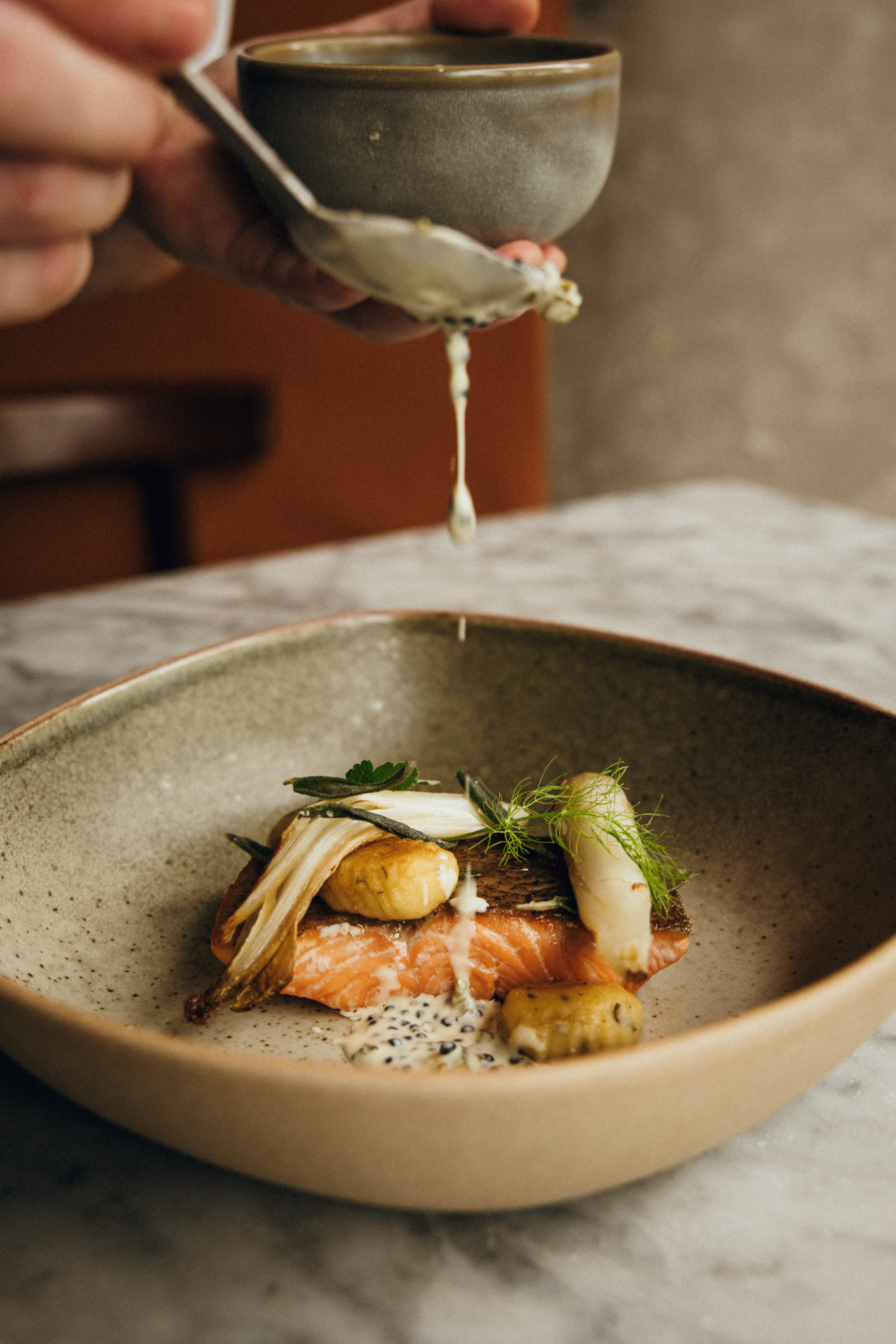 Plated fish dish with sauce drizzle over the top