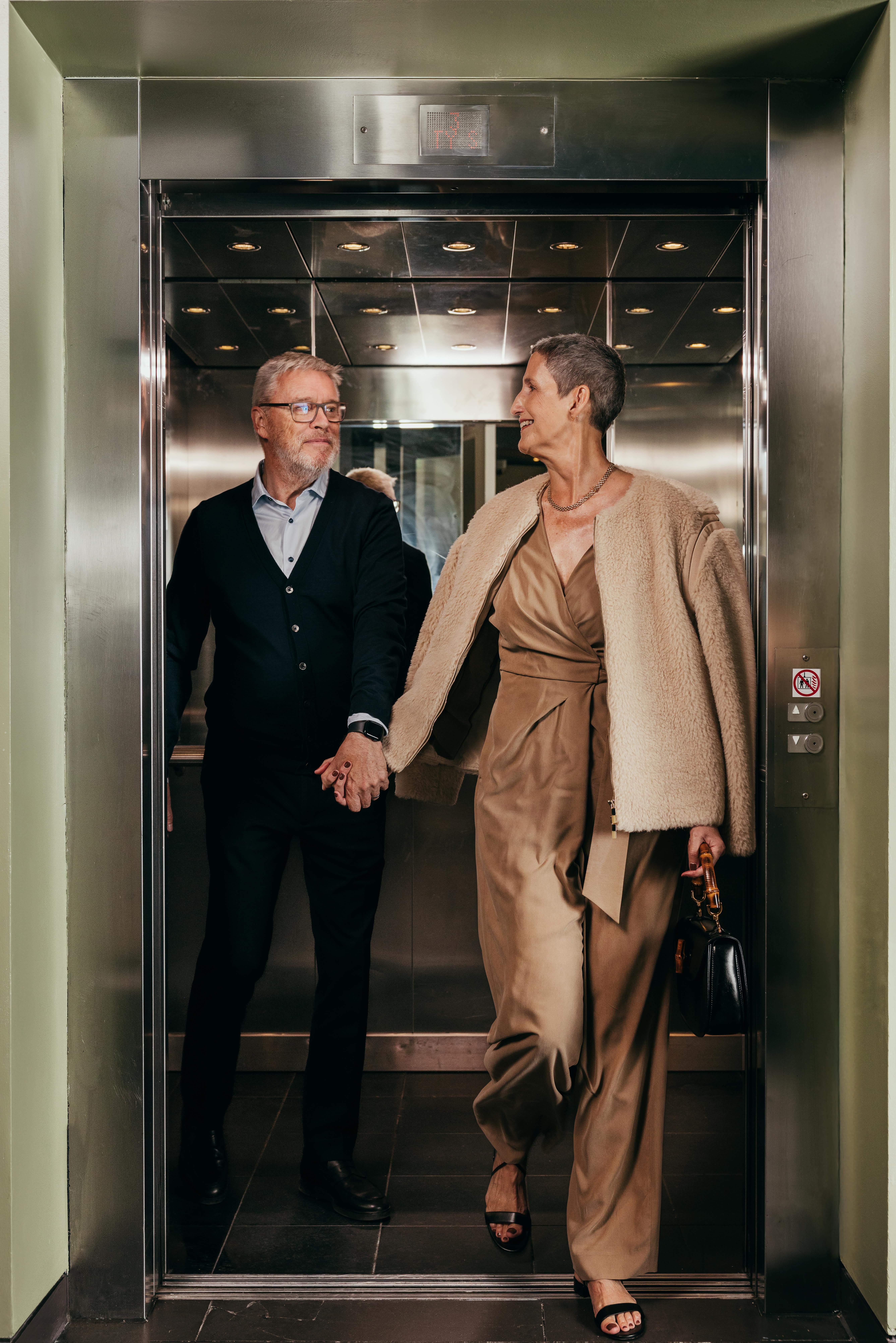 Glamorous couple aged 50-70 leaving an elevator
