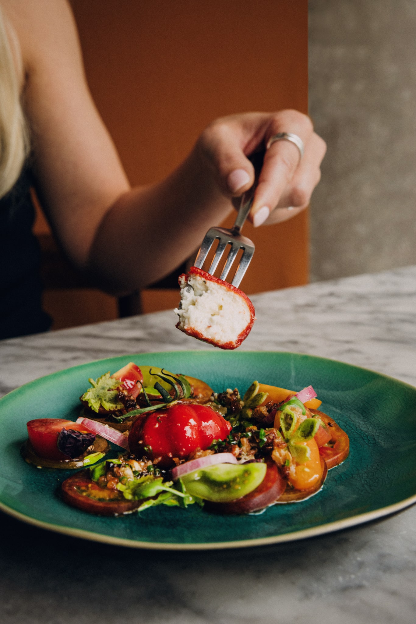 Fork cutting into tomato based dish