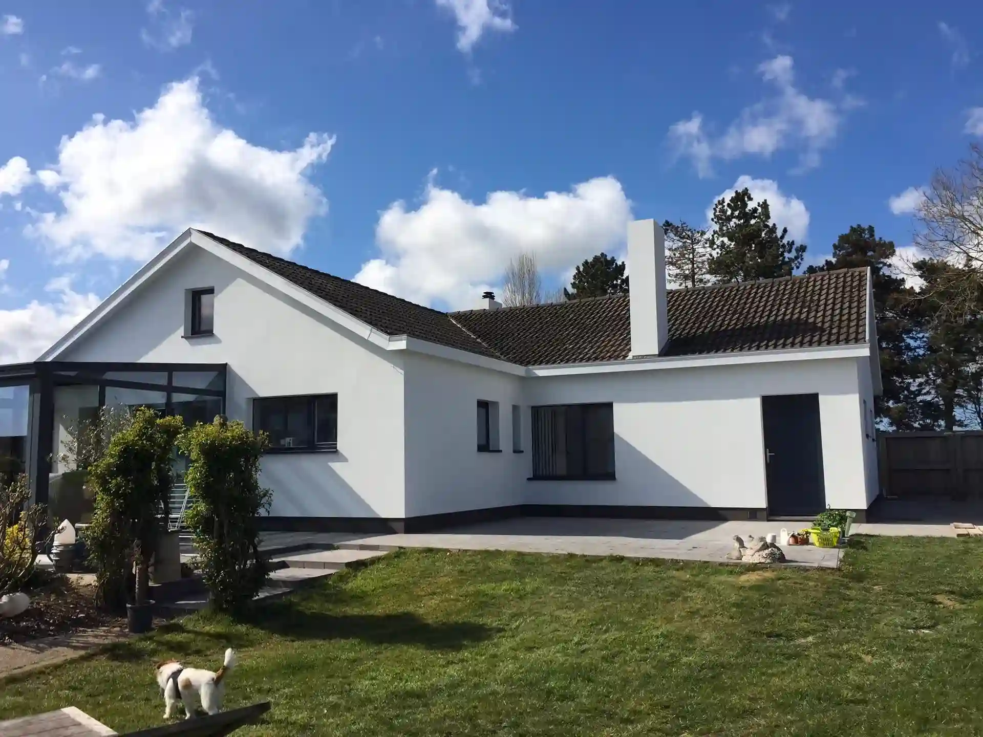 Vrijstaande woning met strakke witte crepi-gevel en donkere kozijnen, gerenoveerd voor optimale isolatie door Energy Protect.