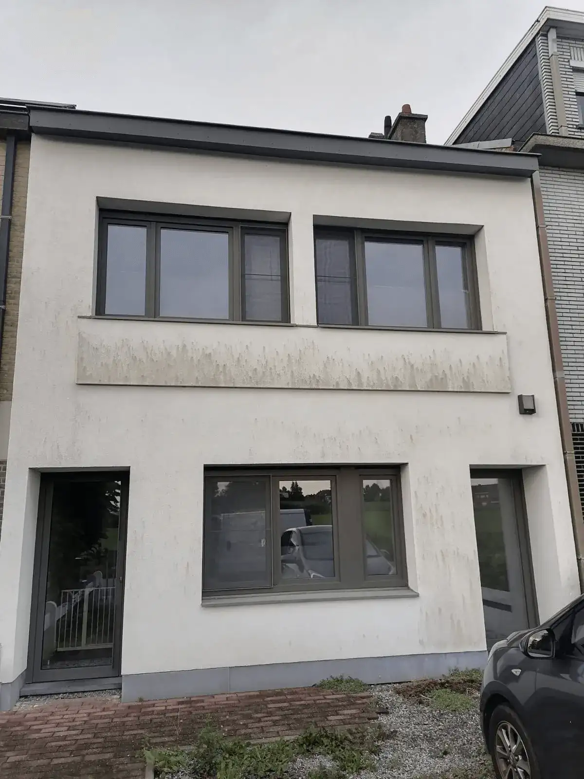 Woning met verouderde witte crepi-gevel en grijze kozijnen vóór renovatie en isolatie-upgrade door Energy Protect.