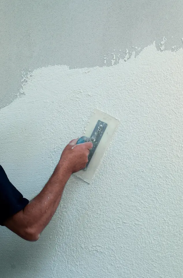 Aanbrengen van sierpleister op gevelisolatie voor duurzame en energiezuinige afwerking.