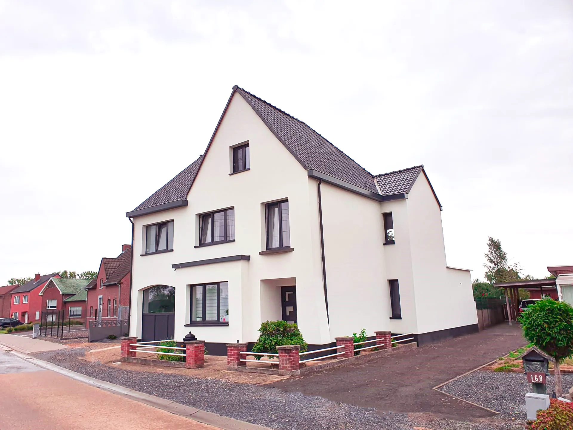Vrijstaande woning met nieuwe gevelisolatie en strakke witte crepi-afwerking voor optimale energiebesparing.