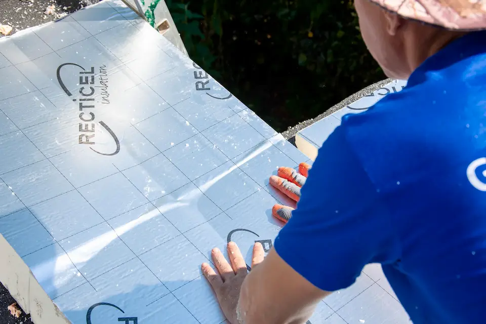 Vakman drukt Recticel isolatiepanelen stevig vast op een plat dak voor optimale dakisolatie en energiebesparing met Energy Protect.