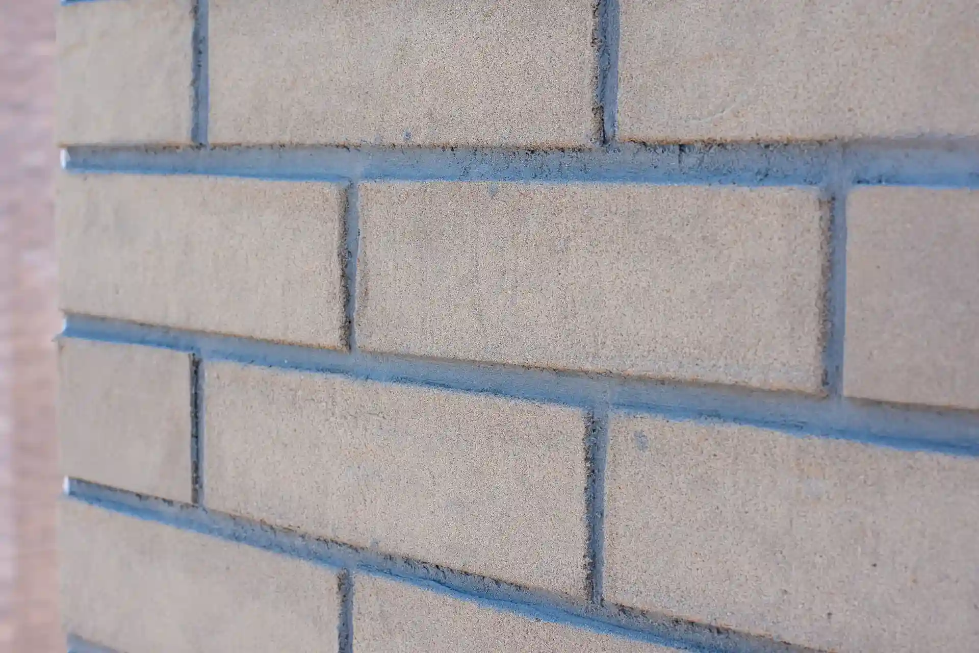 Beige gevelsteenstrips met strakke blauwe voegen, geplaatst voor duurzame isolatie en energiebesparende renovatie door Energy Protect.