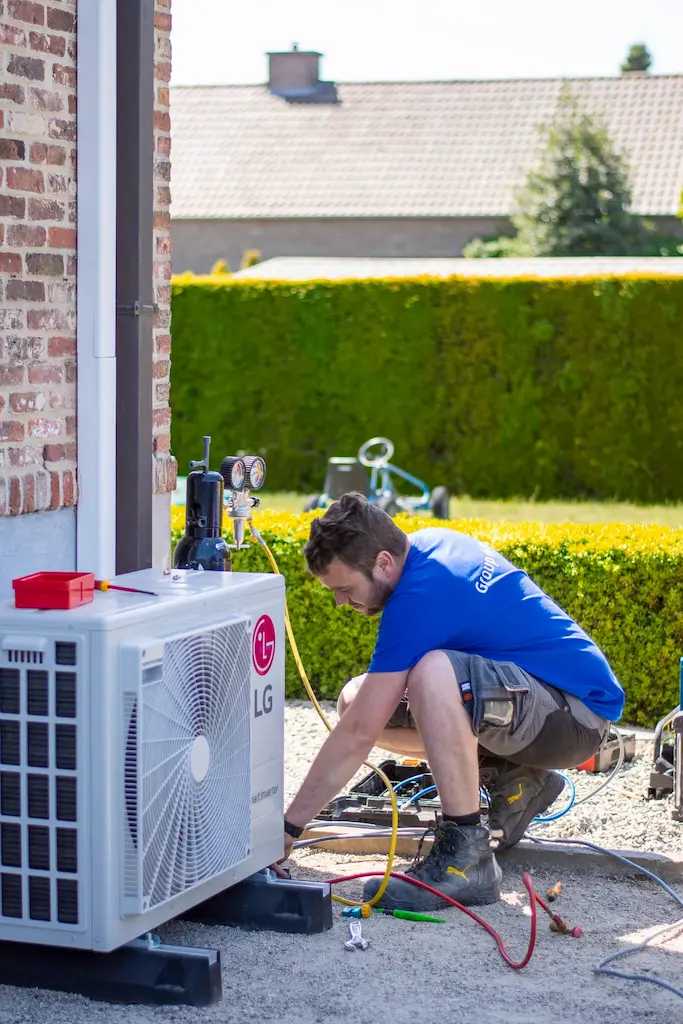 Monteur van Group Protect plaatst LG Smart Inverter buitenunit voor energiezuinige airco-installatie bij woning.