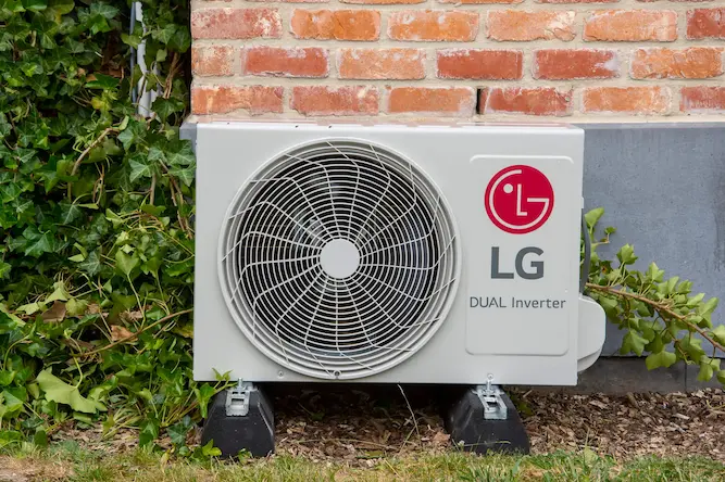 LG Dual Inverter buitenunit naast klimop en bakstenen muur, energiezuinige airco-oplossing van Energy Protect.