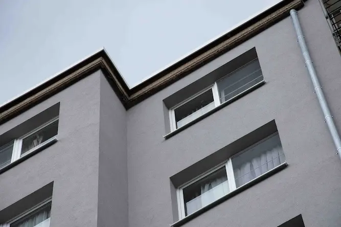 Detail van gerenoveerde appartementsgevel in Antwerpen met strakke grijze gevelisolatie door Energy Protect voor betere isolatiewaarde en moderne look.