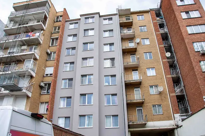 Gerenoveerde appartementsgevel in Antwerpen met strakke grijze gevelisolatie door Energy Protect, voor verbeterde energie-efficiëntie en moderne uitstraling.