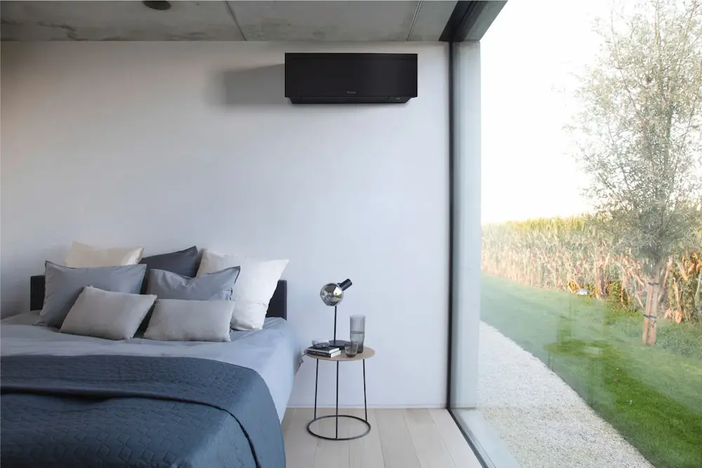 Een stijlvolle zwarte Daikin airco-unit van Energy Protect hangt in een moderne slaapkamer.