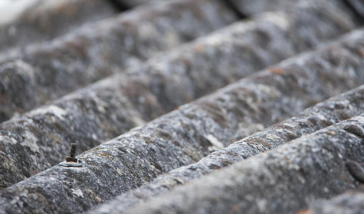 Close-up van verweerde asbestplaten op een dak, geschikt voor asbestsanering en duurzame renovatie door Energy Protect.