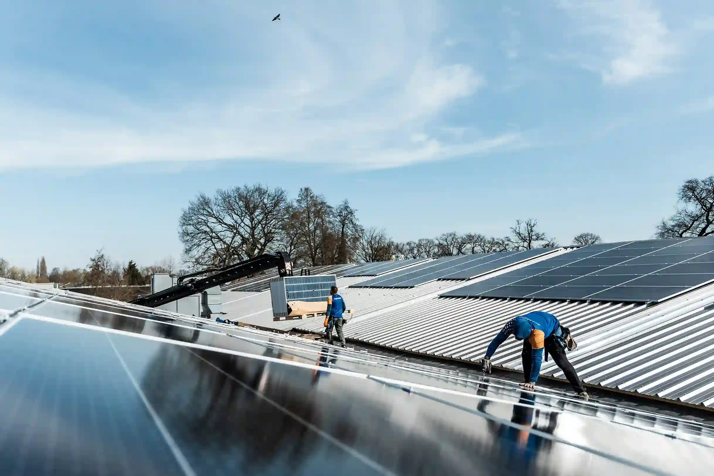 Installateurs van Energy Protect monteren zonnepanelen op een hellend golfplaten dak.