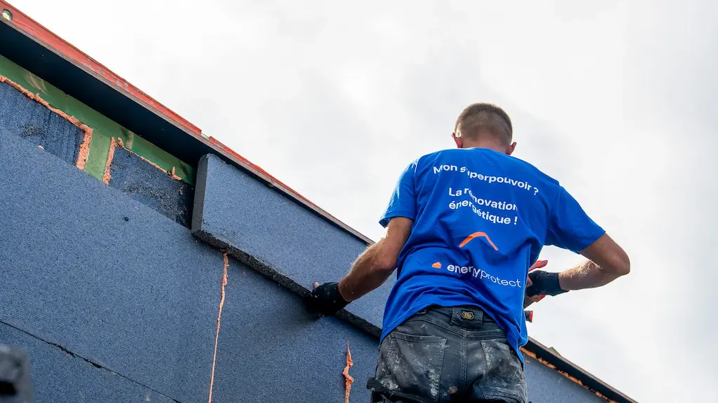 Werknemer van Energy Protect plaatst isolatieplaten tegen een gevel.