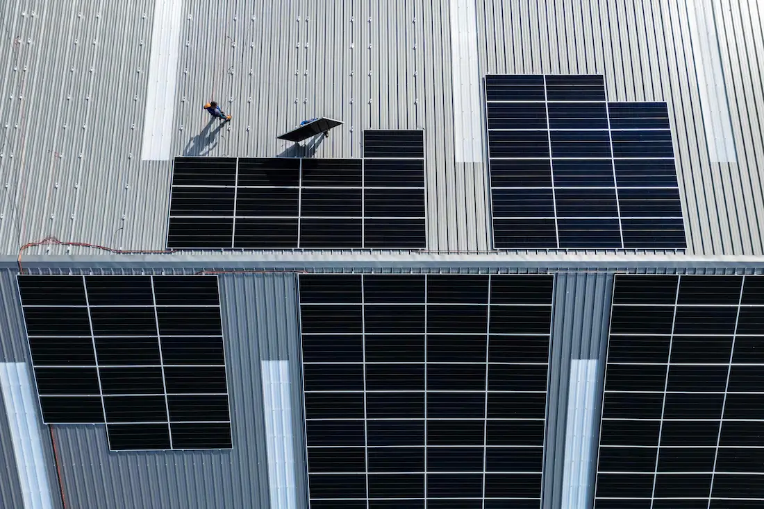 Luchtfoto van een zonnepaneleninstallatie door Energy Protect op een industrieel dak.