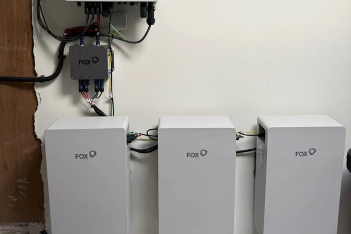 Thuisbatterij met drie batterijmodules en omvormer aan de muur