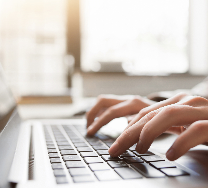 Woman typing on laptop.
