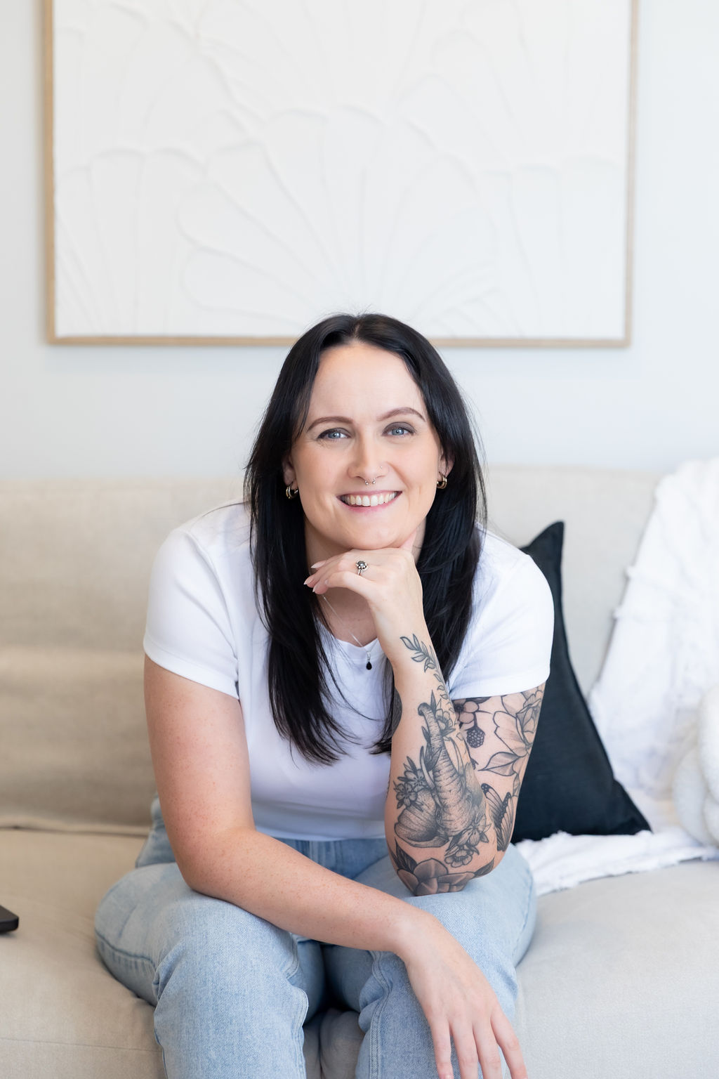Alice Xerri, Founder and Fractional Content Lead, Freelance Copywriter for Finance, B2B Tech and SaaS, sat on couch leaning forward smiling at camera.