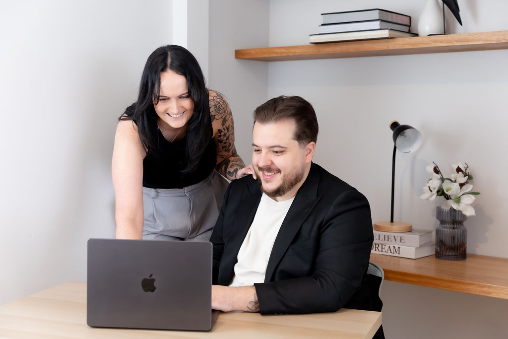 Alice Xerri, Founder and Fractional Content Lead, Freelance Copywriter for Finance, B2B Tech and SaaS, showing client work on laptop while smiling.