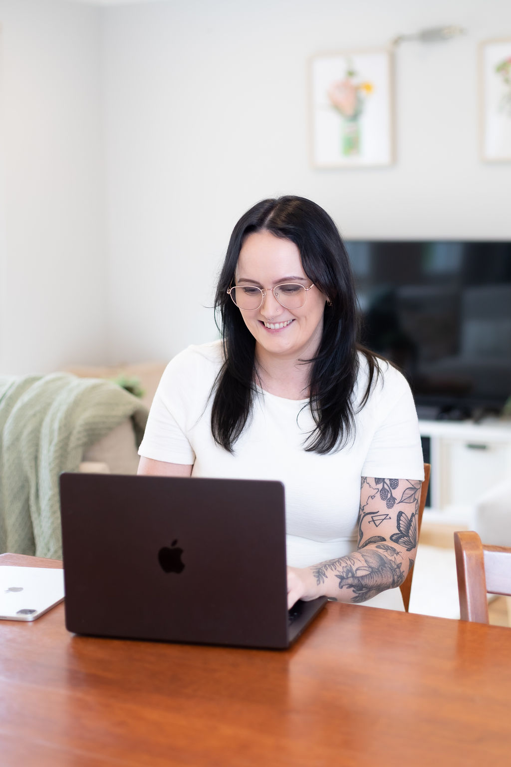 Alice Xerri, Founder and Fractional Content Lead, Freelance Copywriter for Finance, B2B Tech and SaaS, working on laptop while smiling.