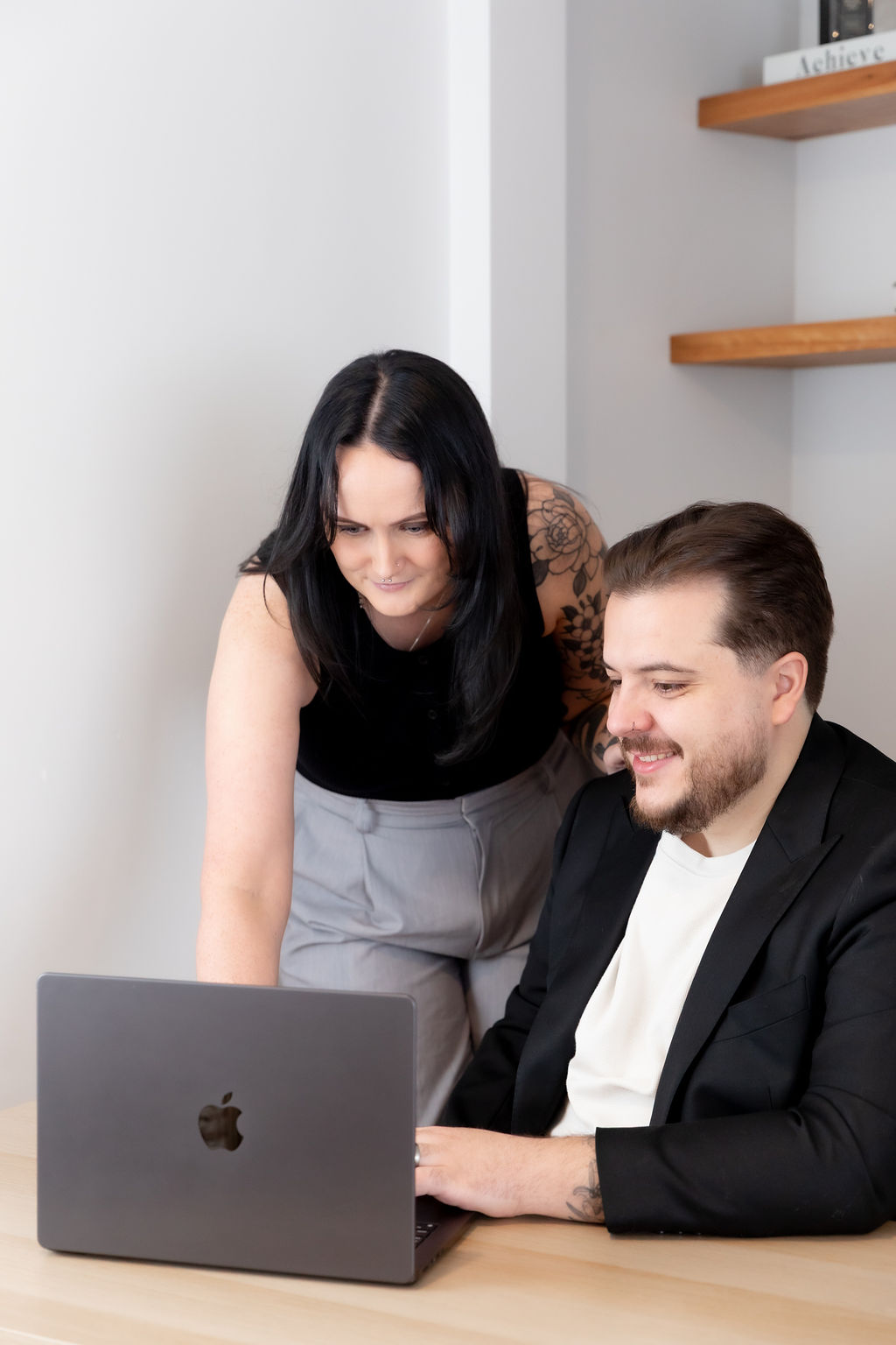 Alice Xerri, Founder and Fractional Content Lead, Freelance Copywriter for Finance, B2B Tech and SaaS, showing client work on laptop while smiling.