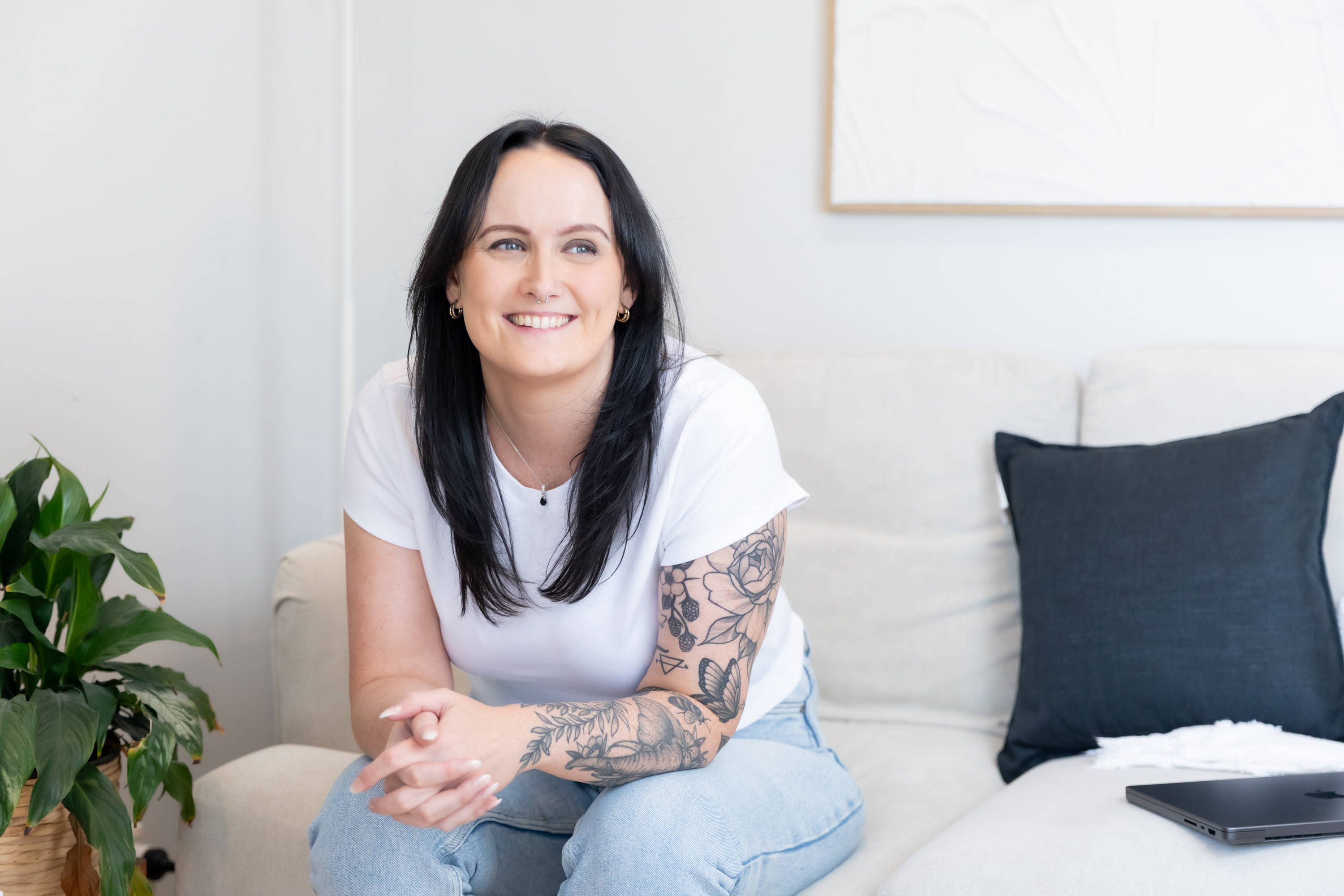 Alice Xerri, Founder and Fractional Content Lead, Freelance Copywriter for Finance, B2B Tech and SaaS, sitting on a couch smiling into the distance.