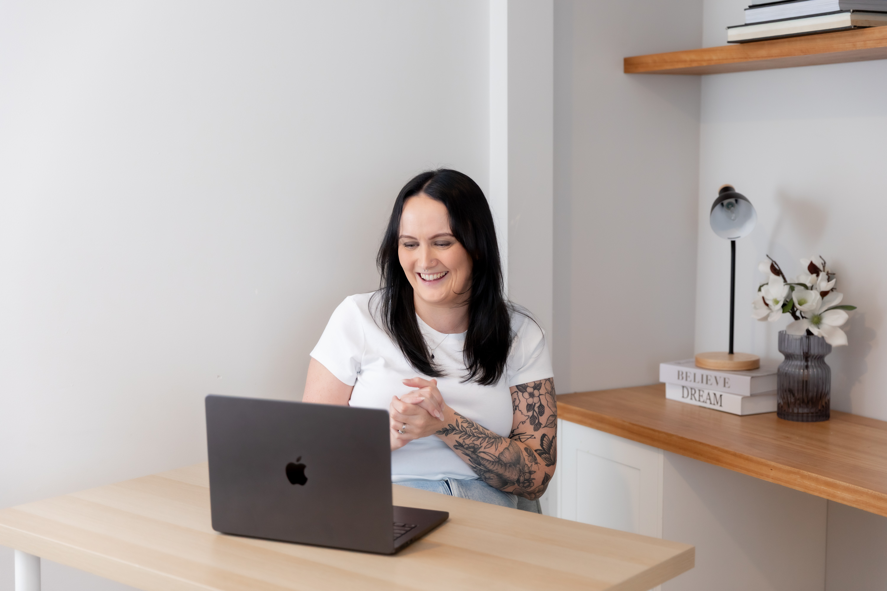 Alice Xerri working on a laptop with an iPad beside her