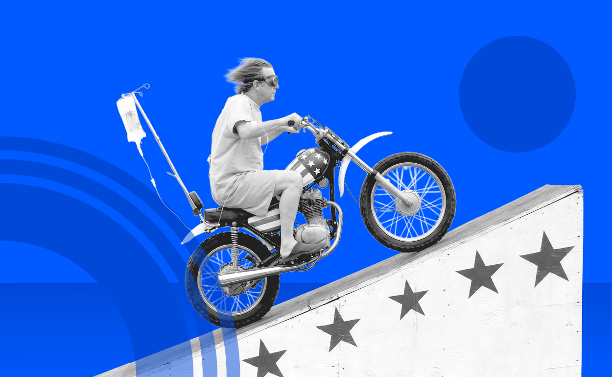 Hospital patient riding daredevil motorcycle up a decorated ramp.