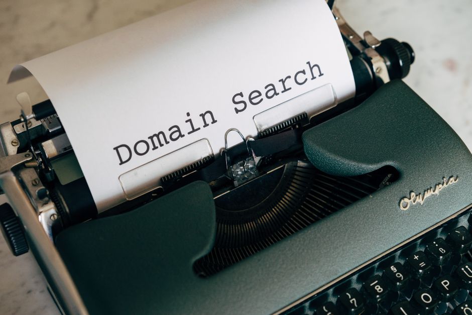 Close-up of a vintage typewriter with paper displaying 'Domain Search' text for conceptual design.. Photo by Markus Winkler on Pexels