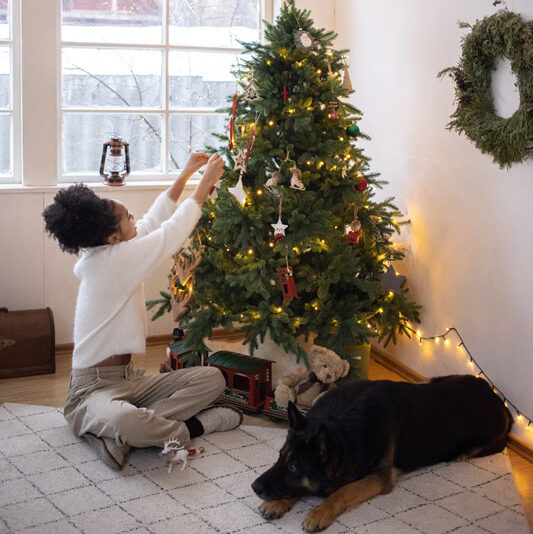 girl decorating tree with her dog