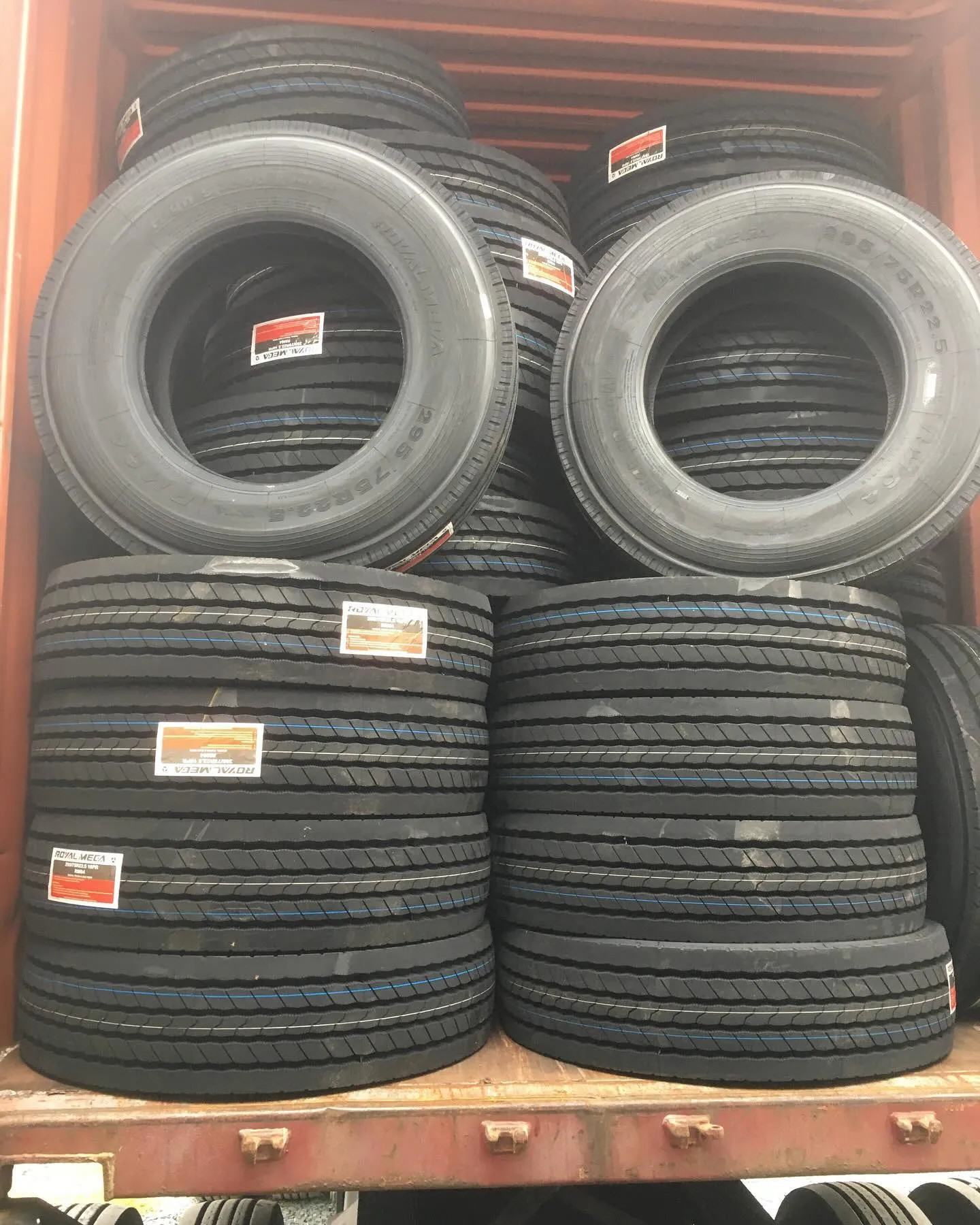 A cargo container filled with neatly stacked tire racks, showcasing various tires with labels visible.