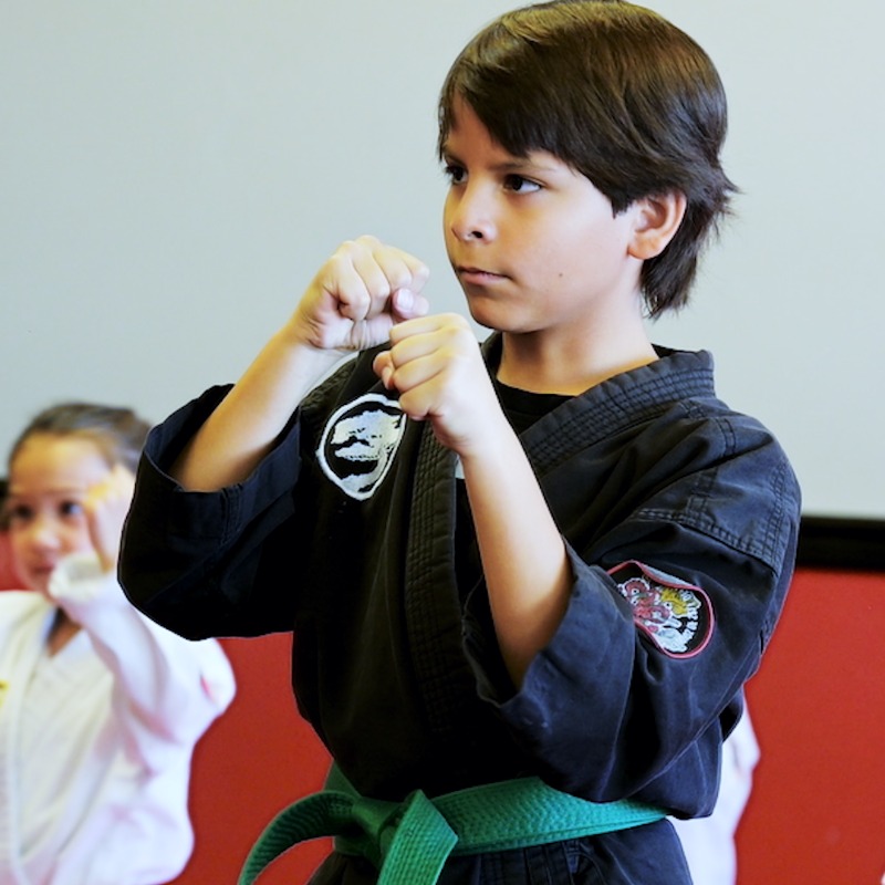 A young karate student stands ready to begin his kids karate class at Costa Mesa.