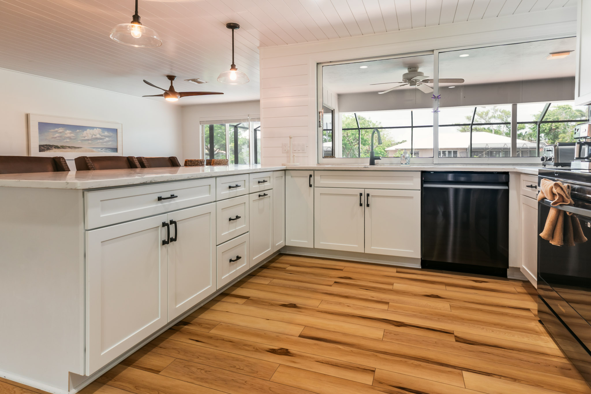 Open-concept kitchen island with view into dining room, showing seamless layout and bright finishes.
