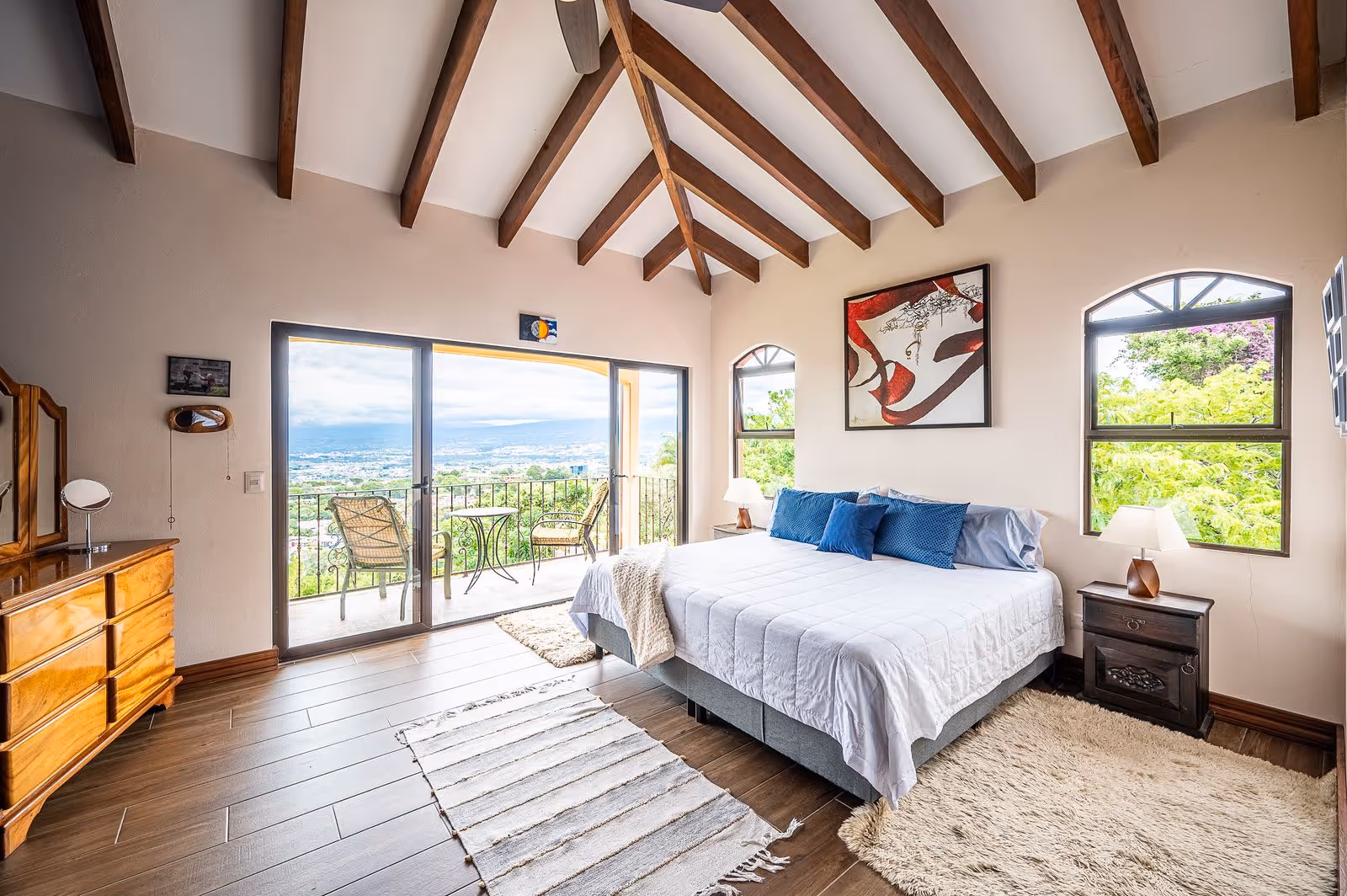 Spacious master bedroom with city skyline views and natural light in Escazu Estate.
