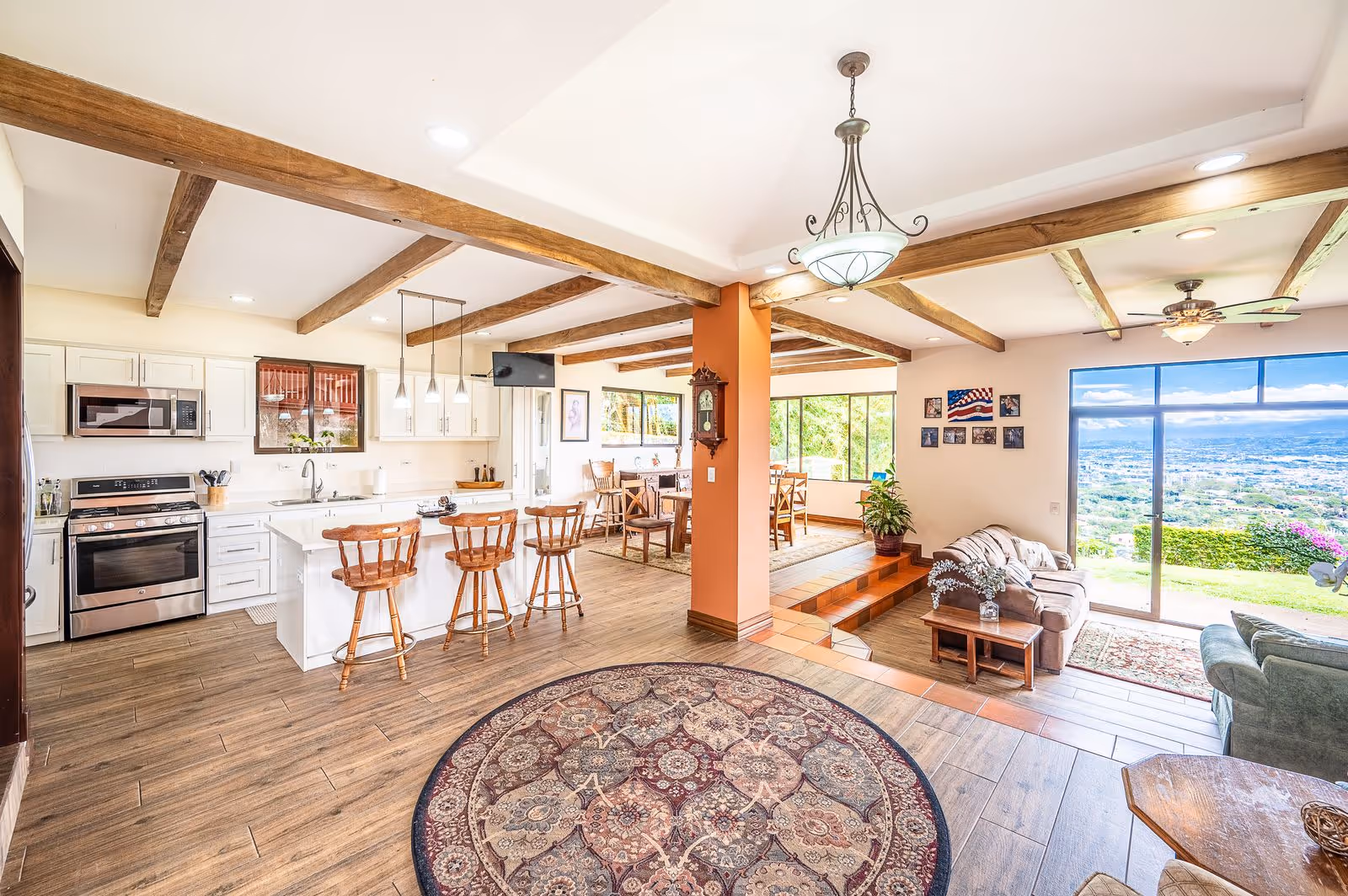 “Open-concept entrance of luxury Escazú estate showcasing panoramic city views, Spanish-style flooring, and elegant interior design with natural light.