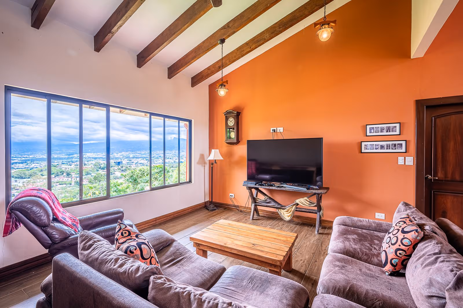 Second-floor open TV and game room in luxury Escazú estate featuring panoramic city views, cozy entertainment space, and abundant natural light.