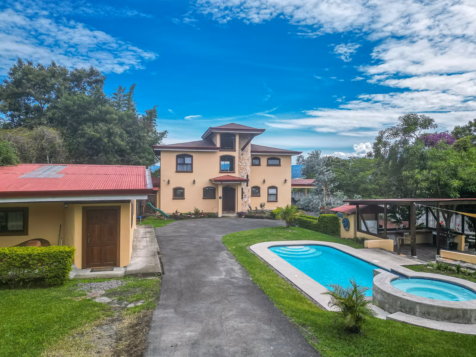  Escazu lux estate view from secondary gated entrance showing private pool, jacuzzi, guest villas, main house, and roofed BBQ area. 