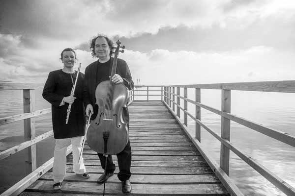 Beatrix Wagner und Gerald Eckert mit Musikinstrumenten in der Hand an der Ostsee