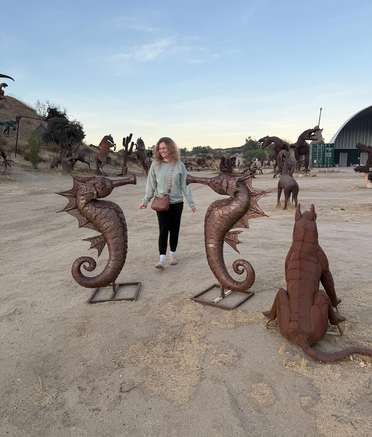 An Image of Marissa with two seahorse sculptures.